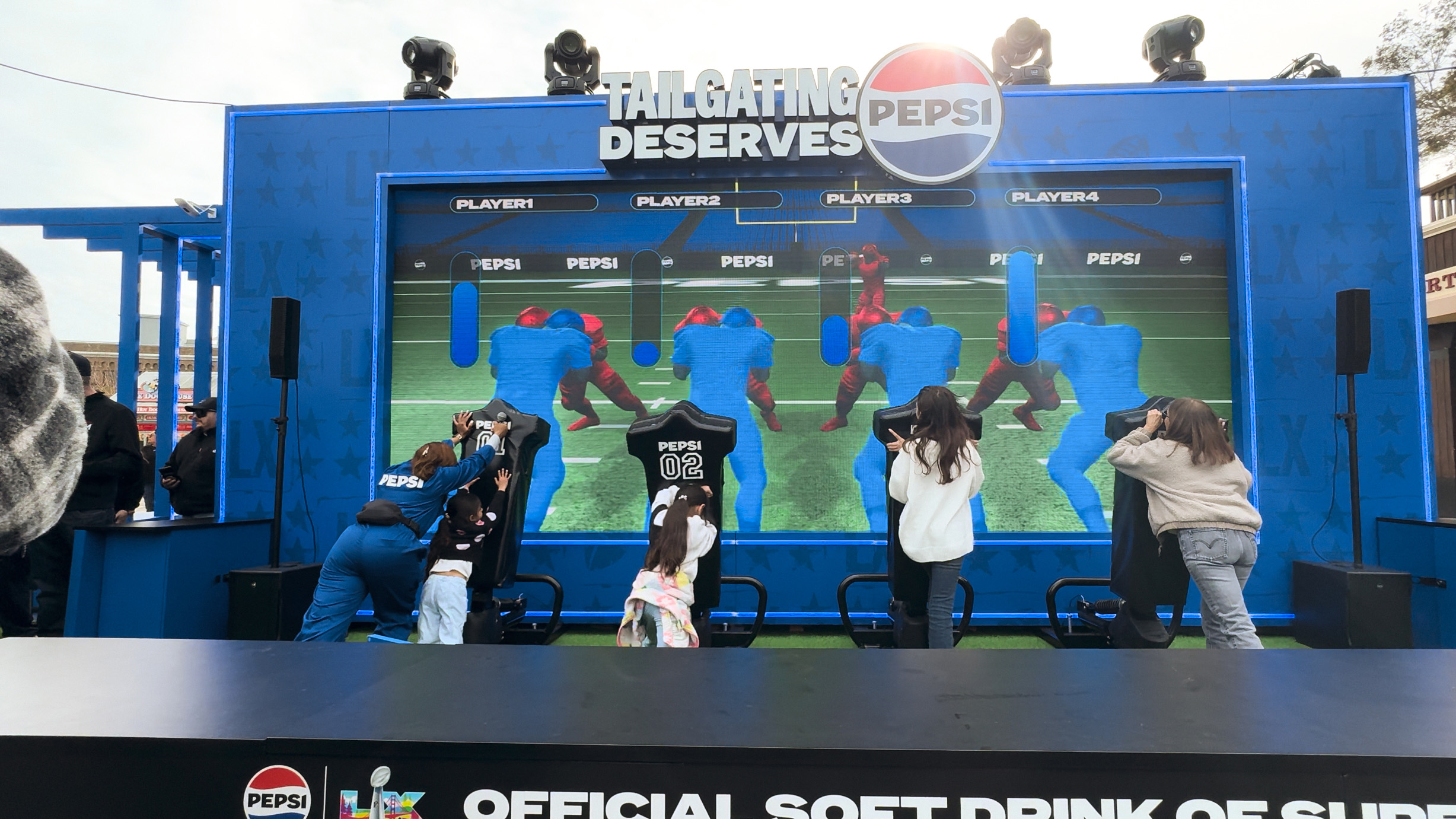 Pepsi interactive football game installation at Super Bowl LX brand activation, participants playing
