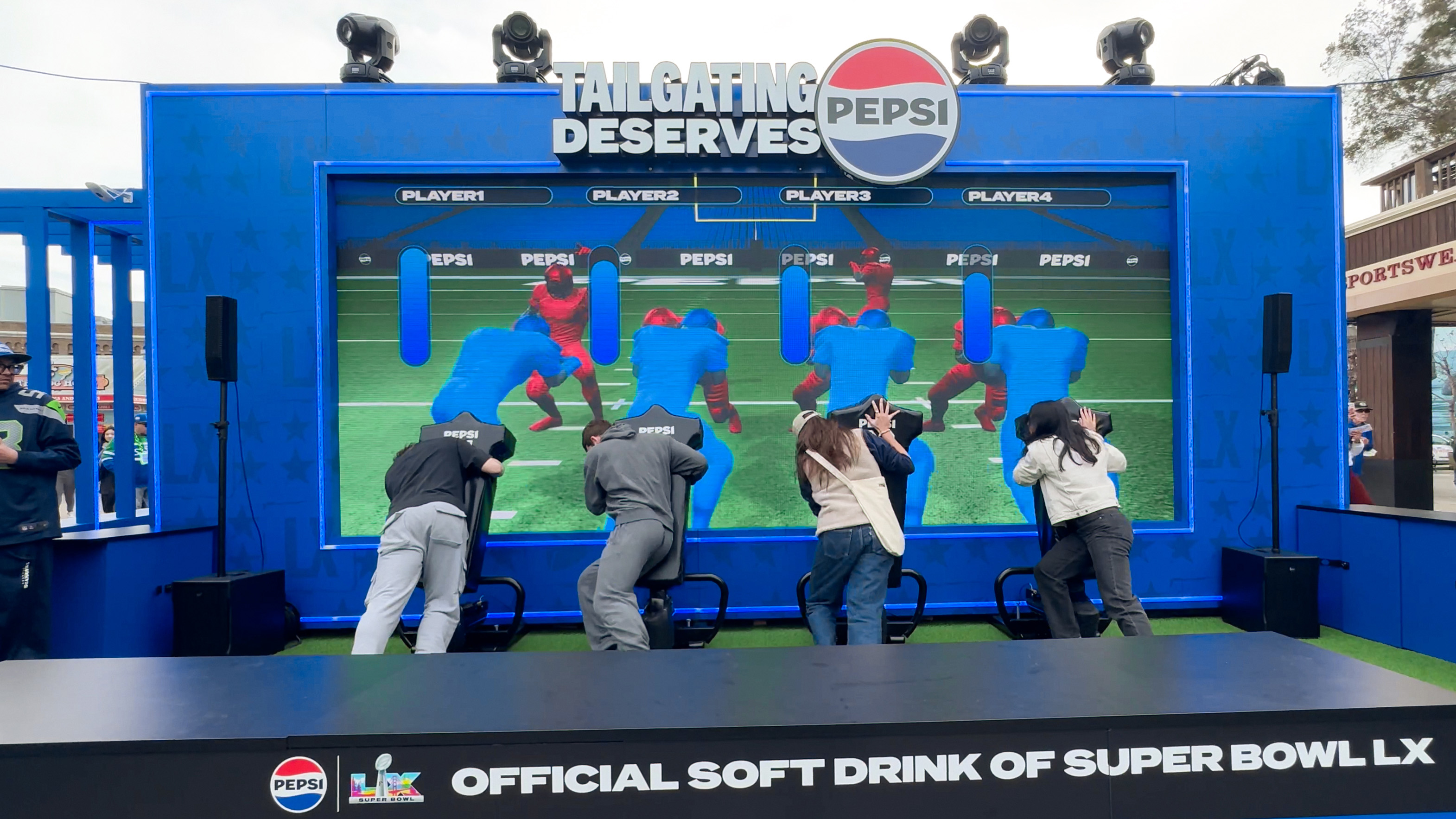 Pepsi interactive football game installation at Super Bowl LX brand activation, participants playing